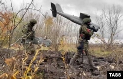 Руски войници носят дрон Орлан-10.