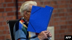 Йозеф С. прикрива лицето си в началото на първото заседание по делото му в Бранденбург, 7 октомври 2021 г.