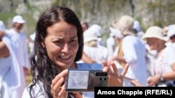 Представителка на братството, която носи лика на Петър Дънов на телефона си.