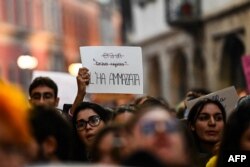 Жена държи плакат със задраскан надпис "беше добро момче", под който пише "той я уби", по време на демонстрация пред университета в Милано по повод убийството на 22-годишната студентка Джулия Чекетин, 22 ноември 2023 г.