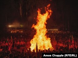 Посетителите наблюдават с любопитство как огънят става все по-голям.