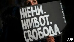 Жена с транспарант по време на протест срещу насилието над жени в София. Снимката е архивна