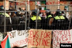 Полицаи стоят до протестиращите пред Амстердамския университет, 8 май 2024 г.