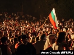 Мъж развява българското знаме преди запалването на големия огън на 19 август.