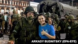 Жена позира с бойците на Вагнер, докато се подготвят да напуснат центъра на Ростов на Дон на 24 юни.