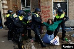 Полицаи извеждат протестираща от Амстердамския университет, 8 май 2024 г.