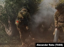 Руски войник носи нашивка със съветското знаме, докато стреля с гаубица в Луганска област в Украйна, 4 октомври 2023 г.