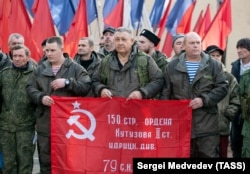 Мобилизирани руски новобранци и доброволци държат знамето на съветската победа, докато се готвят да напуснат Оренбург, Русия, октомври 2022 г.