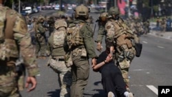 Полицаи задържат мъж в Лос Анджелис по време на протести срещу масовите експулсирания на незаконни мигранти, 7 юни 2025 г.