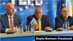 Бойко Борисов обръща пред медиите бележката, подадеа му по време на брифинг заедно с премиера Росен Желязков и вицепремиера Томислав Дончев в партийната централа, 8 юли 2025 г.