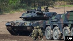Войници стоят до боен танк Leopard 2 A7 на германските въоръжени сили по време на учение на НАТО във военен полигон в Мюнстер, Германия, 20 май 2019 г.