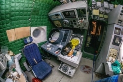 Работното място на радиста. Сатор разказва, че някои места на "Лун" са били замърсени с остатъци от "пиле и торти" от хората, които са подготвяли кораба за експонирането му в тематичния парк