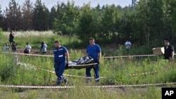 Служители на руските служби носят тялото на бившия транспортен министър на Русия Роман Старовойт, 7 юли 2025 г.