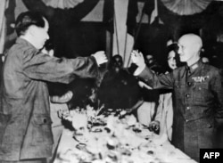 Лидерът на китайските комунисти Мао Дзедун (вляво) вдига тост с лидера на националистите Чан Кайшъ в края на Втората световна война през 1945 г.