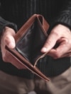 Man holding empty wallet. No money