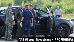 Следователи правят оглед на автомобилът Тесла, в който е намерен прострелян прясно уволненият руски транспортен министър Роман Старовойт, 7 юли 2025 г.