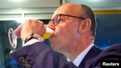 Германският консервативен кандидат за канцлер и лидер на Християндемократическия съюз (ХДС) Фридрих Мерц пие бира след обявяването на резултатите от екзитпола за общите избори през 2025 г. Партията му стана първа политическа сила при най-високата избирателна активност от 35 г.