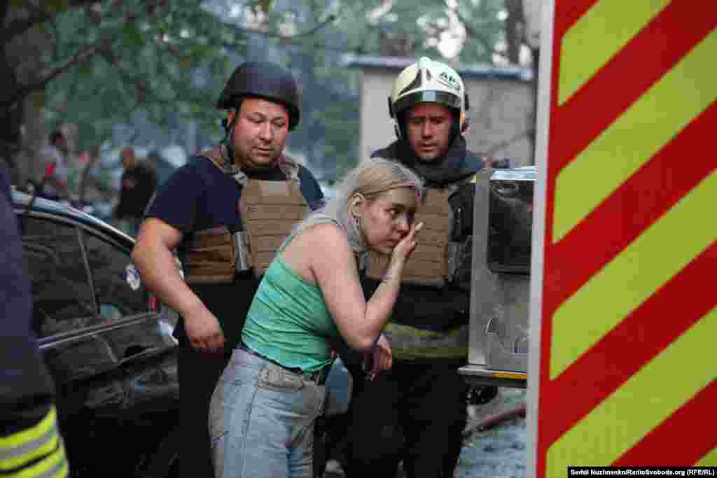 Оцеляла жена чисти лицето си, след като е изведена от зоната на опасност. 