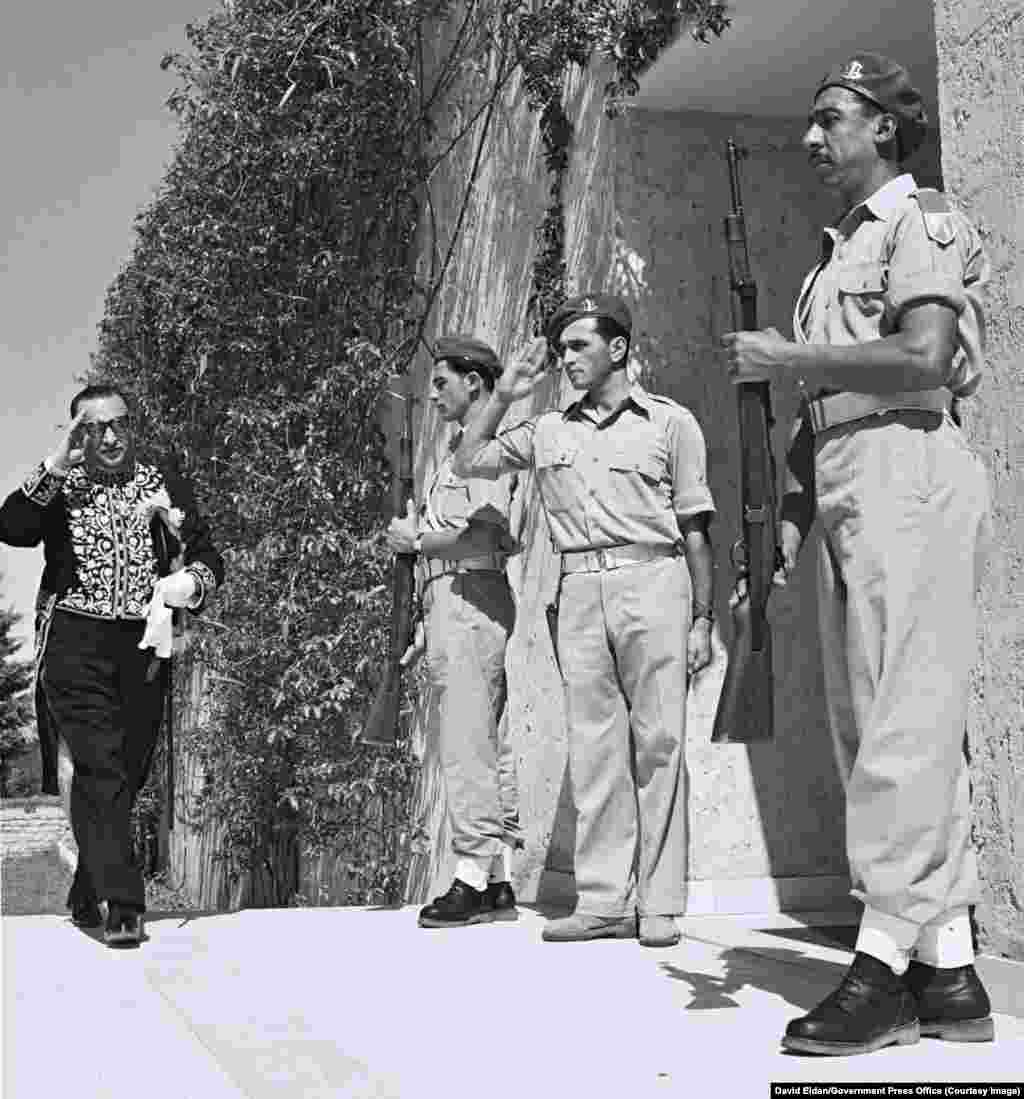 Иранският дипломат Реза Сафиния поздравява израелските войници, докато влиза в резиденцията на първия президент на Израел, Хаим Вайцман, близо до Тел Авив през 1950 г. През 1950 г. Иран прекъсва отношенията с арабските си съседи, като неофициално признава зараждащата се еврейска държава.