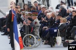 Президентът на Франция Еманюел Макрон (вляво) се среща с ветерани по време на церемония на Триумфалната арка по случай 80-годишнината от Деня на победата в Европа.