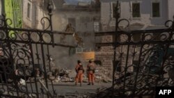 Спасители търсят оцелели сред руините, причинени от руските ракетни удари в украинския град Суми, 14 април 2025 г.