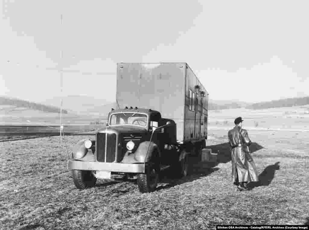 Въоръжен пазач пази предавател в камион в Западна Германия, който се намира в близост до границата с Чехословакия през 1955 г.След като комунистическите държави започват да блокират сигнала на RFE и RL, американската медия разполага десетки мобилни предаватели, които могат да работят по-близо до Желязната завеса.