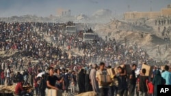 Палестинци носят чували и кутии с храна и хуманитарна помощ, разтоварени от конвой на Световната хранителна програма, който се е насочвал към град Газа в северната част на Газа, понеделник, 16 юни 2025 г.