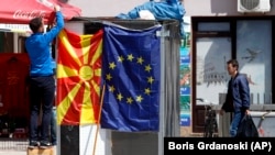 Продавач закача македонското знаме до това на ЕС в Скопие.