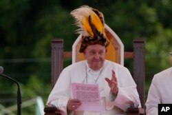 Папа Франциск носи традиционна шапка по време на среща с вярващи във Ванимо, Папуа Нова Гвинея,