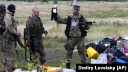 Проруски сепаратист държи детска кукла, намерена сред останките от MH17