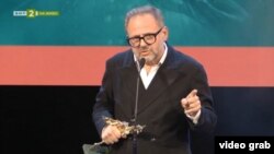 Самуел Финци с наградата Икар в ръка.