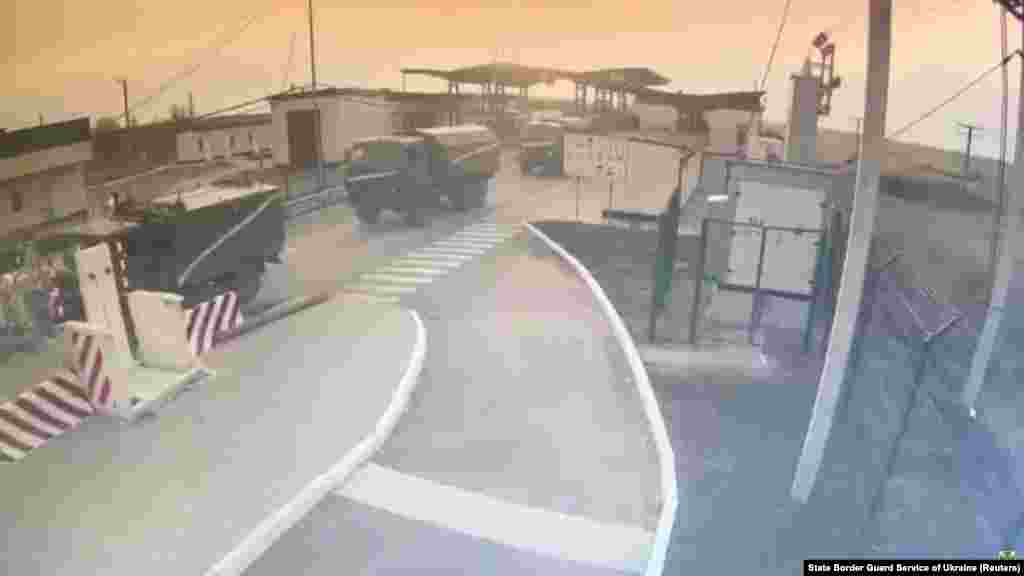 На този кадър от видео се вижда как военни превозни средства преминават в украинската Херсонска област от Крим през ГКПП Каланчак.