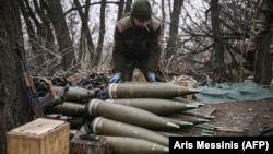 Украински военен подготвя за изстрелване 155-милиметрови снаряди близо до Бахмут, Украйна, през март 2023 г.