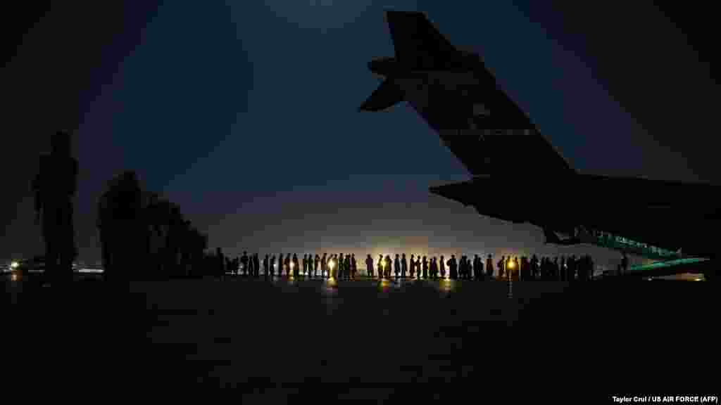 Екипаж на ВВС на САЩ се готви да качи евакуирани на борда транспортни самолети на 21 август.