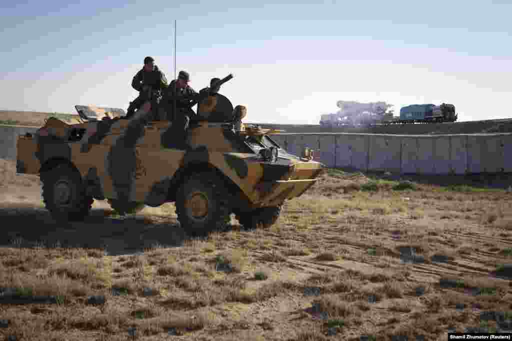 Руски военнослужещи наблюдават от бронетехника, докато транспортират &quot;Союз&quot; до стартовия панел. Байконур е смятан&nbsp;за потенциална мишена за терористични атаки. &nbsp;