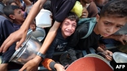 Деца се редят на опашка за храна пред един от пунктовете за разпределение на помощи в Нусейрат, Централна Газа, 11 юни 2025 г.