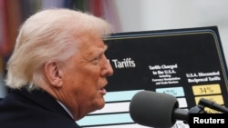 Президентът на САЩ Доналд Тръмп показва таблица, в която са посочени новите мита, наложени на други държави, 2 април 2025 г.