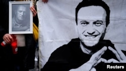 Жена държи свещ и портрет на Алексей Навални, който загина в руски затвор отвъд Полярния кръг преди 10 дни. Барселона, Испания, 25 февруари 2924 г.
