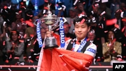 Джао Синтонг позира със световната титла по снукър и китайския национален флаг в "Крусибъл тиатър" в Шефилд, Великобритания, 5 май 2025 г.