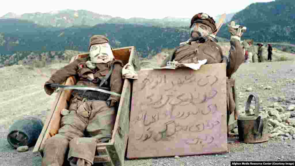 Кукли на съветски войници, поставени на планински път след нахлуването на СССР в Афганистан през 1979 г. Надписът гласи: &quot;Сестрите на Шахр-е Нау&quot; - квартал в Кабул - &quot;плачат, а сестрите на комунистите си вадят очите&quot;.